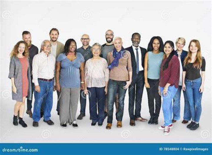 a group of people standing next to each other in front of a cross