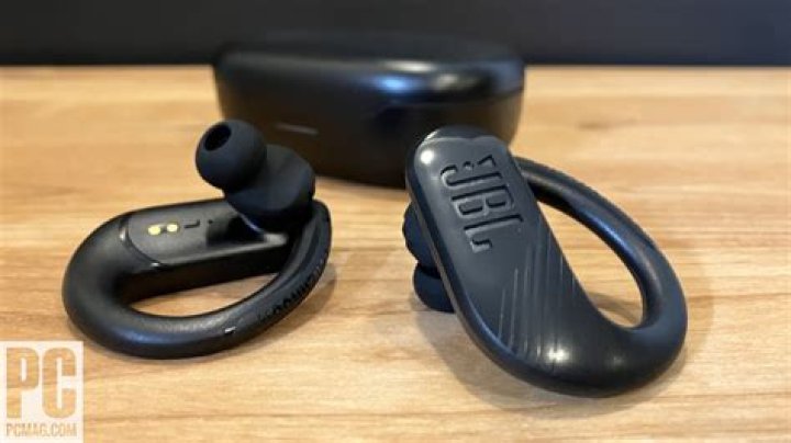 JBL Endurance Peak III in their charging case, hand-held.