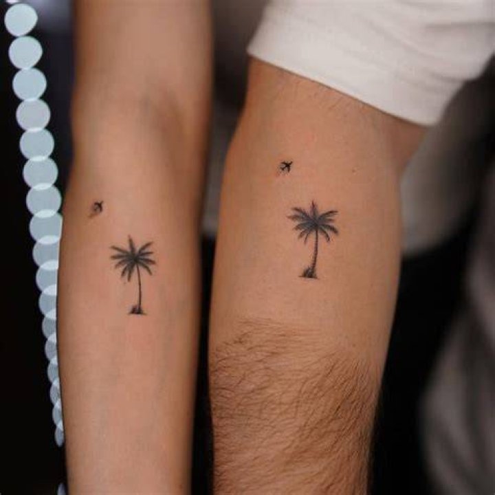 Matching palm tree tattoos on the ankle.